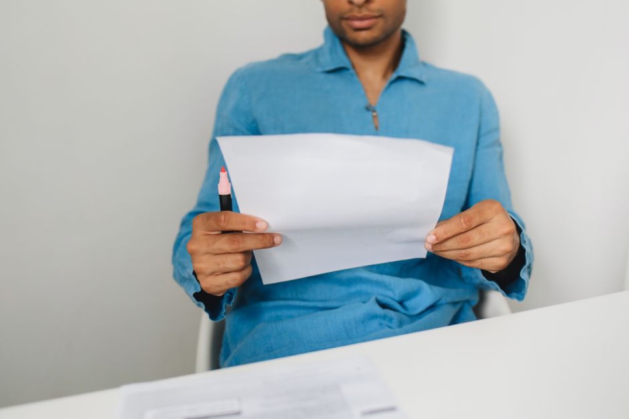 Reading a letter at desk - Medical aid cancellation letter: free template and how to send it